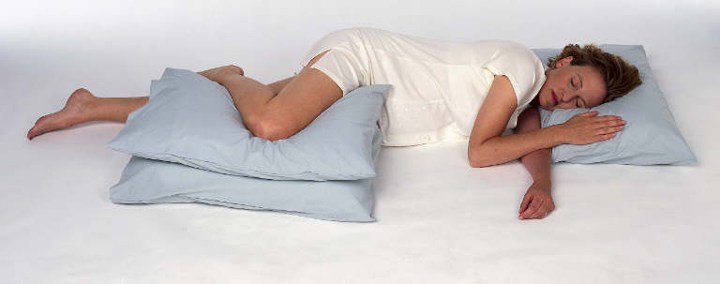 Tidur Menyamping dengan Memeluk Bantal di Antara Lutut