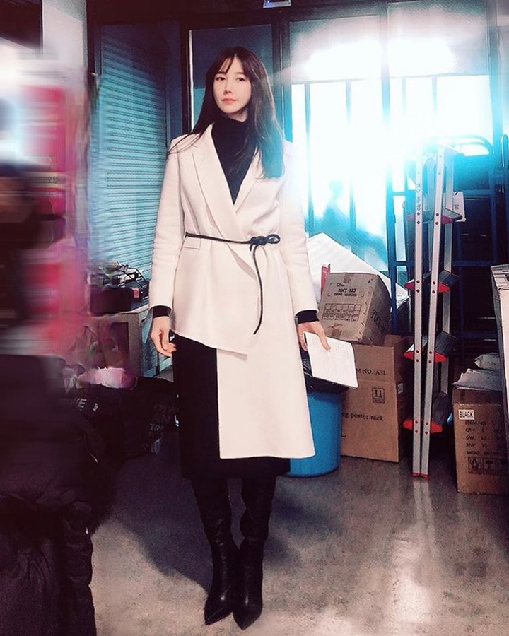 Lee Ji Ah memadukan outfit hitam favorit dengan outer pink muda