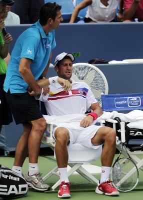 Gambar Foto Novak Djakovic mendapat perawatan dari medis pada lengannya kanannya yang cedera
