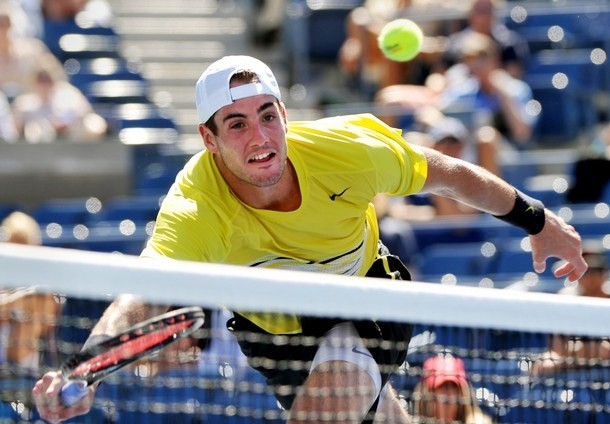 Gambar Foto John Isner berusaha mengembalikan bola dari Andy Murray