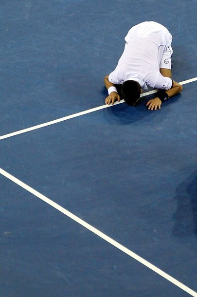 Gambar Foto Novak Djokovic tersungkur dan menciup lapangan usai memenangkan laga final atas Rafael Nadal