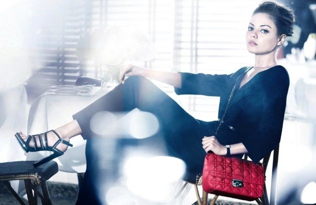 Gambar Foto Mila Kunis Dengan Gaun Hitam dan Tas Merah Miss Dior