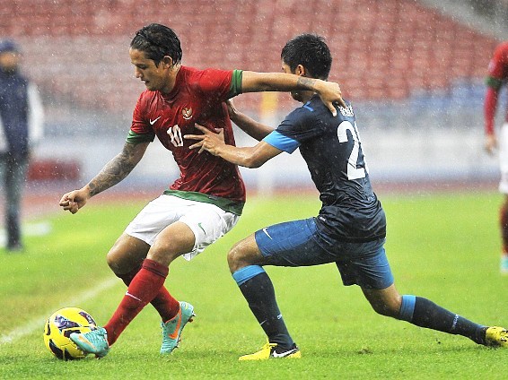 Gambar Foto Irfan Bachdim Mempertahankan Bola dari Serangan Muhammad Irwan Shah