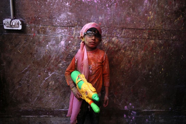 Gambar Foto Seorang Anak Kecil Berpose dengan Pistol Air Penuh Warna