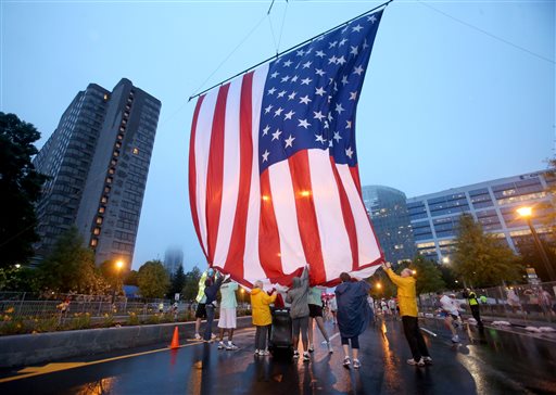 Gambar Foto Relawan Mengibarkan Bendera Amerika Serikat di Perlombaan Lari AJC Peachtree Road Race