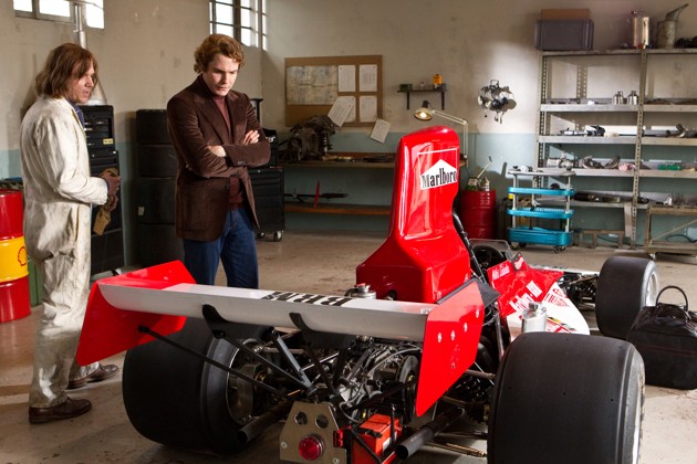 Foto James Hunt Menunjukan Mobilnya pada Niki Lauda