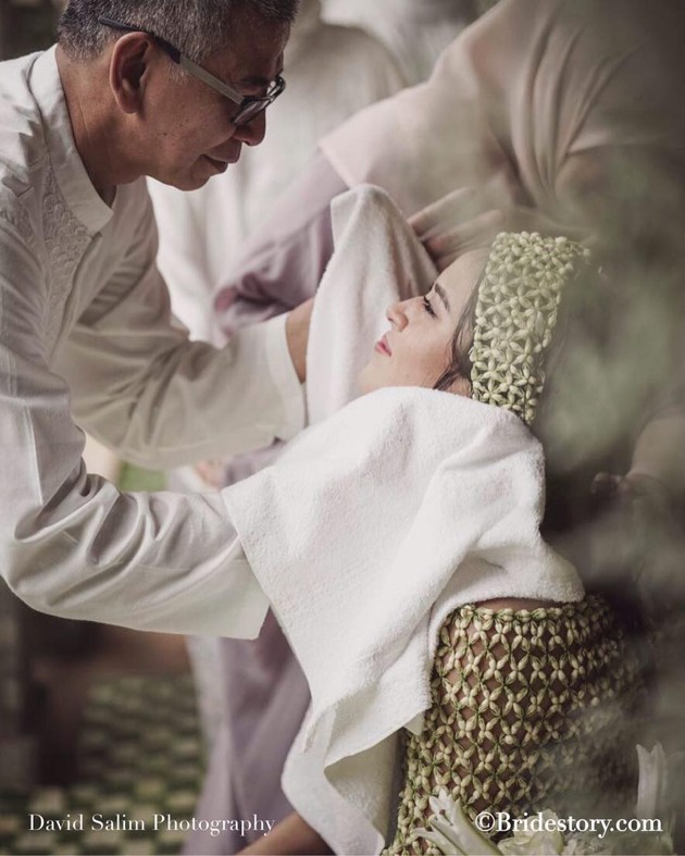 Gambar Foto Setelah selesai Siraman, sang ayah dengan telaten mengeringkan tubuh Raisa dengan handuk putih.