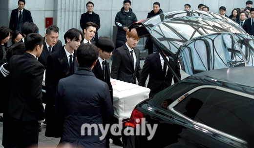 Foto Para personel SHINee dan Super Junior memasukkan peti jenazah Jonghyun ke dalam mobil.