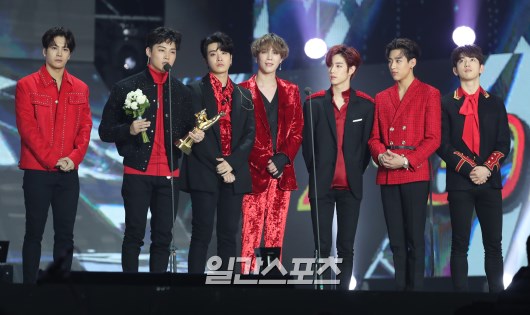 Foto GOT7 berbalut kostum panggung mereka saat menerima penghargaan Disc Bonsang di Golden Disc Awards 2018.