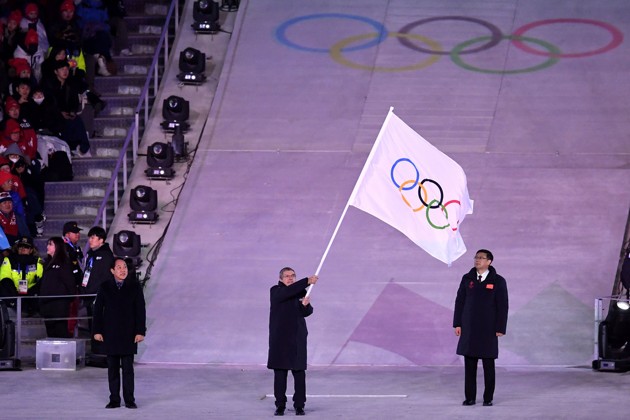 Gambar Foto Presiden Komite Olimpiade Thomas Bach terlihat membawa bendera Olimpiade.