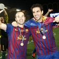 Andres Iniesta (kiri) rayakan kemenangan Barcelona dengan Cesc Fabregas
