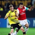 Kapten Arsenal, Robie van Persie, (kanan) dihalangi oleh Sven Bender