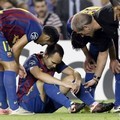Andres Iniesta terduduk di lapangan setelah mengalami cedera saat menghadapi AC Milan