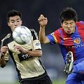 Pemain Basel asal Korsel, Joo Ho Park (kanan) memblok bola yang dari pemain Benfica, Nicolas Gaitab