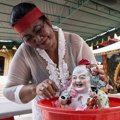 Seorang Wanita Membersihkan Patung Budha di Kuil Dwipayana Tanah Kilap