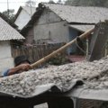 Warga Membersihkan Kerikil yang Ada di Atas Atap Rumah