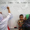 Seorang Pengunjung Menuliskan Pesan Dukungan untuk Para Korban