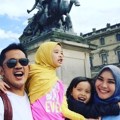 Zaskia dan Hanung Bramantyo tersenyum riang saat berfoto di depan Museum Louvre Paris