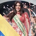 Masih dalam balutan gaun malam andalannya, Tulia Aleman Ferrer bangga memamerkan bendera Venezuela.