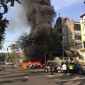Suasana di depan Gereja GPPS setelah terjadinya ledakan bom bunuh diri. Tampak api membakar beberapa kendaraan bermotor dan asap tebal membubung tinggi.