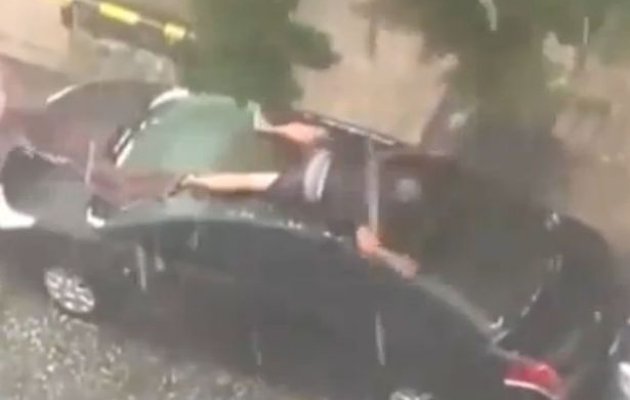 Pria Ini Tutupi Mobil dengan Tubuh Agar Tidak Kena Hujan Es