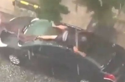 Pria Ini Tutupi Mobil dengan Tubuh Agar Tidak Kena Hujan Es